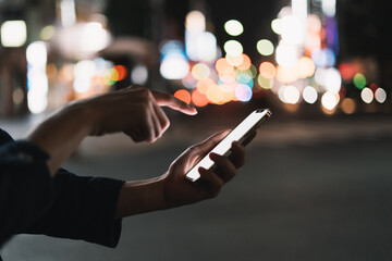 道の上でスマートフォンを開く人