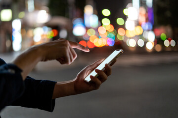 道の上でスマートフォンを開く人