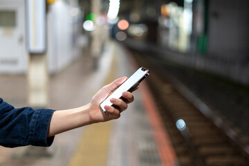 道の上でスマートフォンを開く人