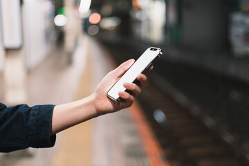 道の上でスマートフォンを開く人