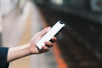 道の上でスマートフォンを開く人