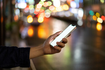 道の上でスマートフォンを開く人