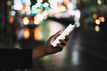 道の上でスマートフォンを開く人