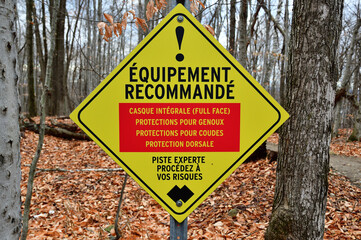 Mountain bike recommended protective gear sign,  French language, Recommended equipment. Full face helmet. Knee pads. Elbow pads. Spine p, Yellow caution sign