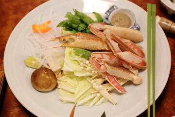 Crab legs top of fresh vegetable for meal in japanese restaurant.