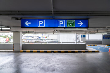 Fototapeta na wymiar Signage Lightingbox in the indoor carparking, tell driver which way is parking lot or exit. Thai Language in green square on lightinbox means EXIT.