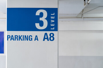 Signage on the indoor carparking pole, tell driver which way to go and location in parking lot.