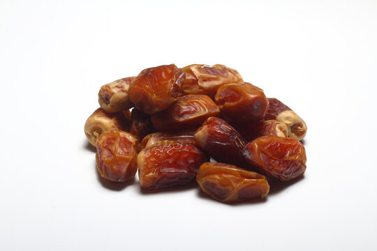 Dates on a white background. Dried fruits. Dried dates lie next to each other	
