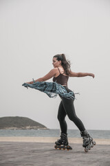 Naklejka premium Mujer patinando en paseo marítimo