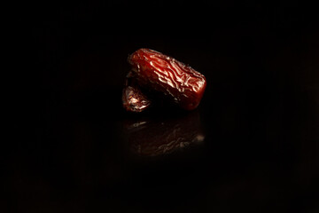 Dates on a black background. Dried fruits. Dried dates lie next to each other	
