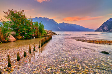 View of the beautiful Lake Garda surrounded by mountains, Scenic view of sunset at Lake Garda in...