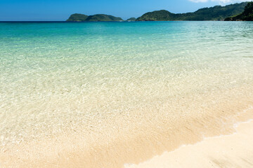 Beautiful white sand beach, crystal clear turquoise water that extends to the horizon, perfect for swimming and relaxing. Iriomote Island.