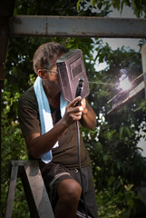 The general welder welding steel structural by use only welding mask for protection intense light...