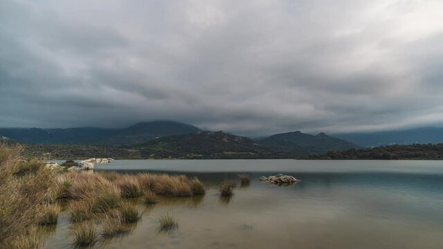 Time-lapse of clouds passing over the mountains of San Parteo and Monte Grosso and the Lac de Codole in the Balagne region of Corsica at sunset
