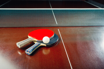 table tennis rackets and ball, net background
