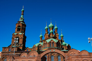 A church with a tower and green domes.
