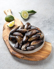 Shellfish raw Mussels on gray plate, gray background. Shellfish seafood. Top view.