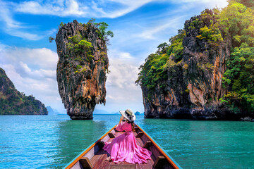 Beautiful girl sitting on the boat and looking to James Bond island in Phang nga, Thailand.