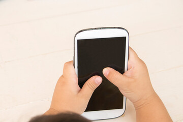 hand of children mobile phone playing on background white
