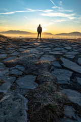 person standing on the hill during the sunrise