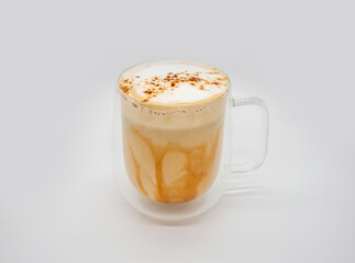 Hot coffee with milky foam sprinkle with cocoa power for decoration in double wall glass isolated on white