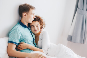 Beautiful couple lying together on the bed loving couple in morning