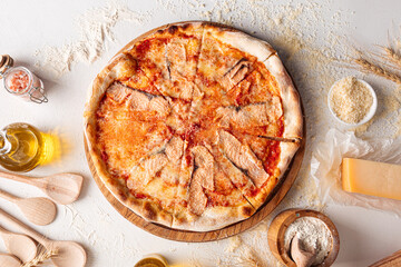 Top view on salmon pizza on the white decorated background