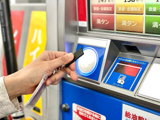 セルフサービス給油機を操作する手元