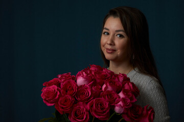 Young woman holding bouquet of roses flowers