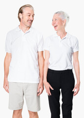 Happy senior couple in white polo shirts with design space studio portrait