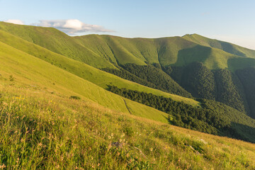 Naklejka premium Summer evening in the Ukrainian Carpathian mountains on Borzhava with a dramatic sunset and tourists watching it