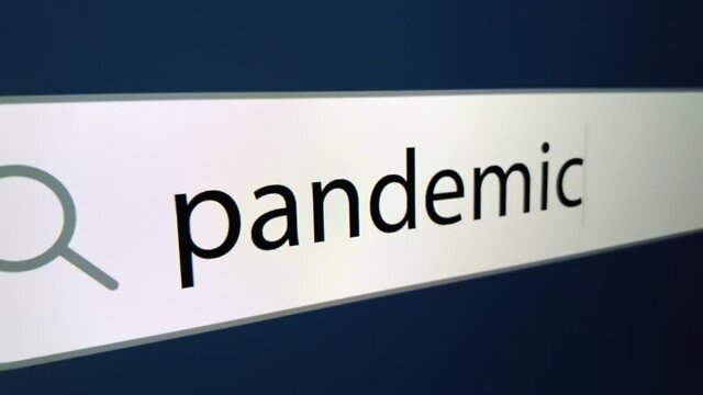 Pandemic written in search bar with cursor and question mark at the end,a computer monitor, close-up with the effect of a camera zoom