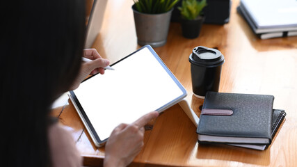 Close up view of businesswoman holding stylus pen writing business plan on digital tablet.
