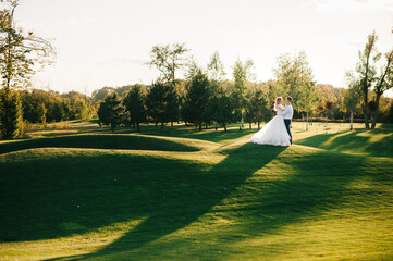 Happy husband and wife. Wedding day. Beautiful nature. Walk during the photo session. They smile at...