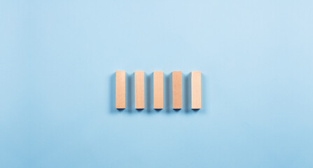 Wooden cubes bars. Stacked in a row. On a blue background. Construction and sequence concept