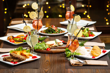 Evening celebration dinner with cocktails on blurry lights