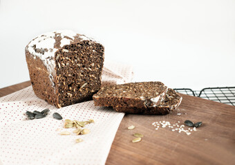 Homemade gluten free buckwheat bread with various seeds on a rack. fresh baked low carb bread covered with napkin