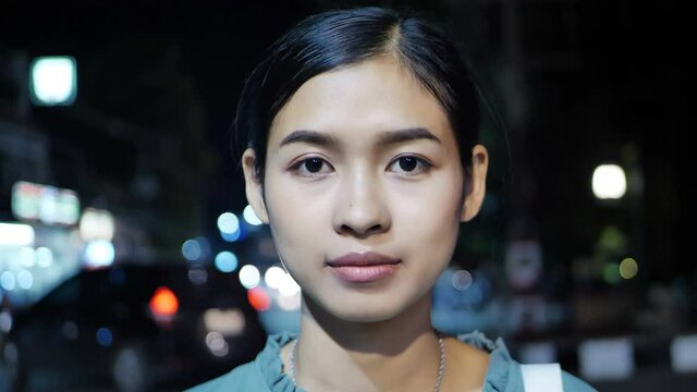 Asian woman wearing a dustproof mask on the street at night.