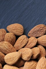 Almond nut. Raw almonds nuts heap on black slate background.Nuts and seeds. Tasty snack. Healthy fats.
