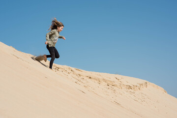 cute little girl playing in the sand dunes