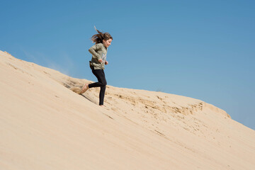 cute little girl playing in the sand dunes