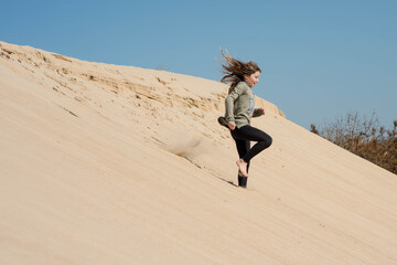 cute little girl playing in the sand dunes