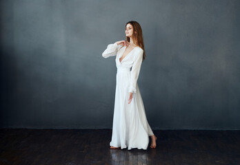Charming lady in a white dress on a gray background dance gesticulating with her hands model