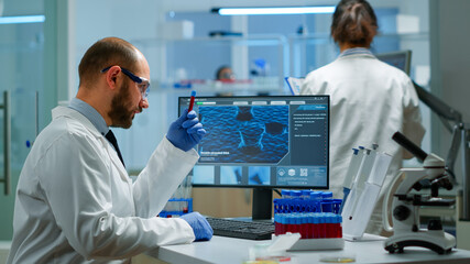 Fototapeta premium Male researcher working in laboratory research and experiment corona disease sample case for medical health technology against covid-19 virus. Viorolog in professional lab analysing vaccine evolution
