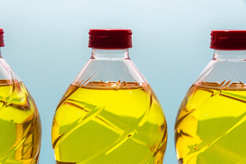plastic bottles with edible soy oil on blue background