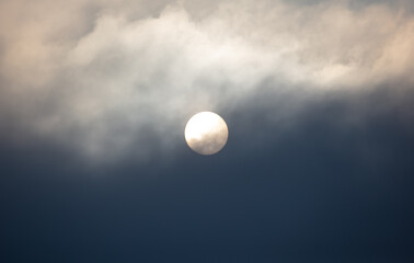 Obraz premium The sun shines behind the clouds during