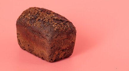 Rye bread sprinkled with cumin seeds on a pink background.