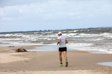 Man is running along the beach in Stegna. Poland