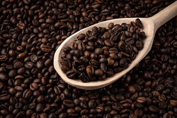 Coffee beans with wooden spoon background or texture.