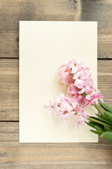 Pink hyacinth flowers and empty card on wooden table. greeting card. Spring coming concept. Spring or summer background